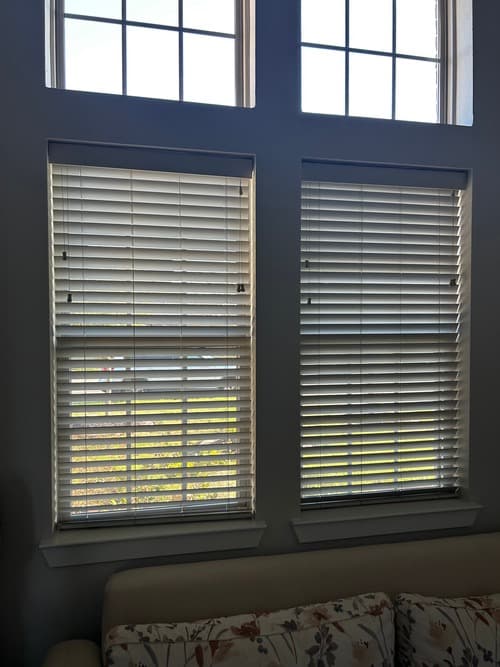 Professional blind installer measuring windows in a Northern NJ home